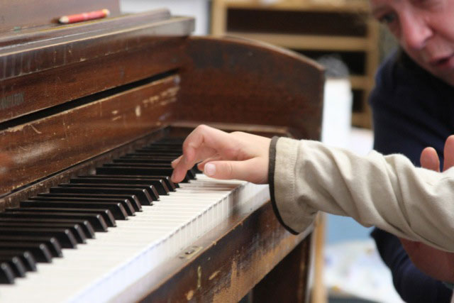 picture of a boy learning to play piano