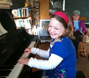 young girl enjoying a piano lesson